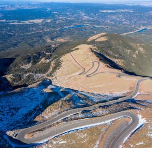 aerial view of pikes peak highway with snow along road